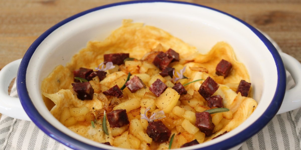 Truita oberta amb botifarra negra, poma i ceba caramel·litzada